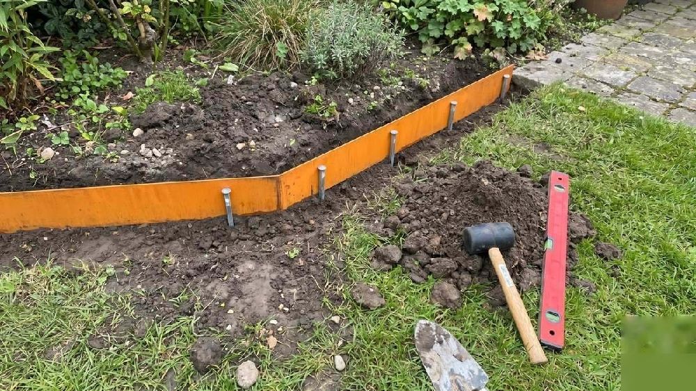 Pose d'une bordure de jardin en acier corten avec piquets de fixation